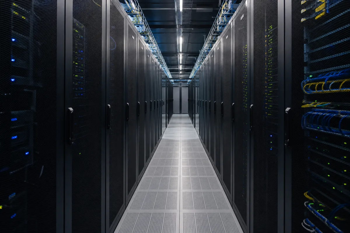 Serveurs informatiques alignés dans une salle technique éclairée en bleu
