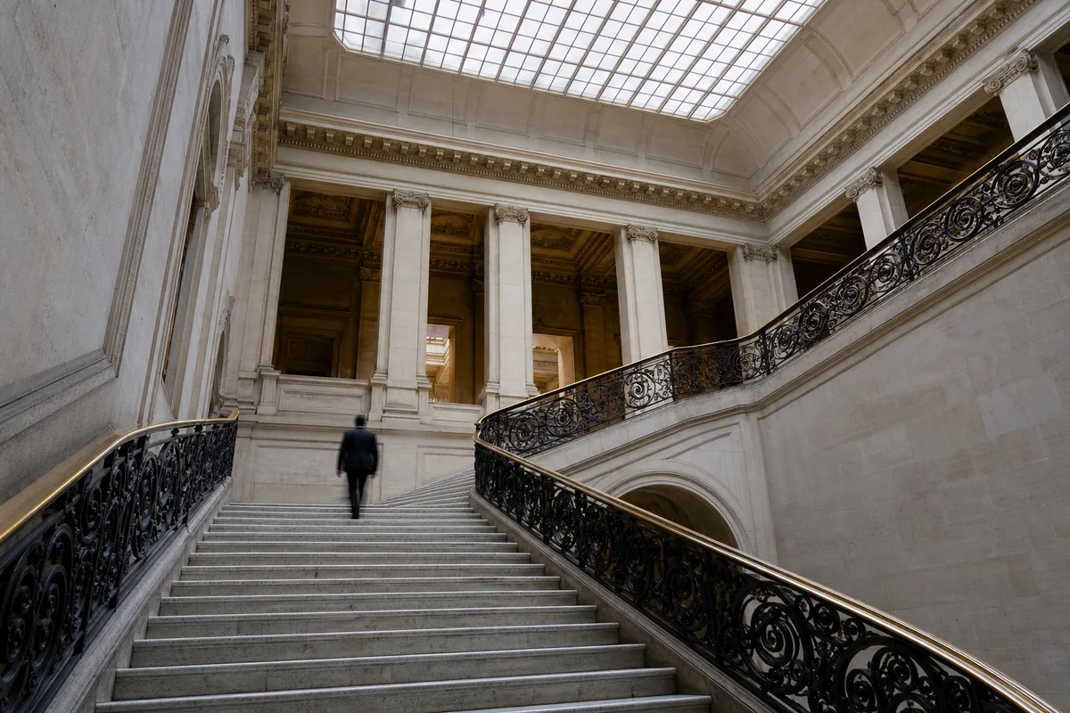 Escalier monumental d’un tribunal avec rampe en fer forgé et marches de marbre